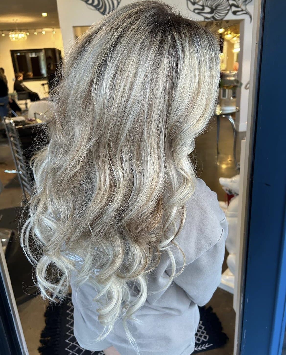 Long, full ash-blonde waves, seen from behind